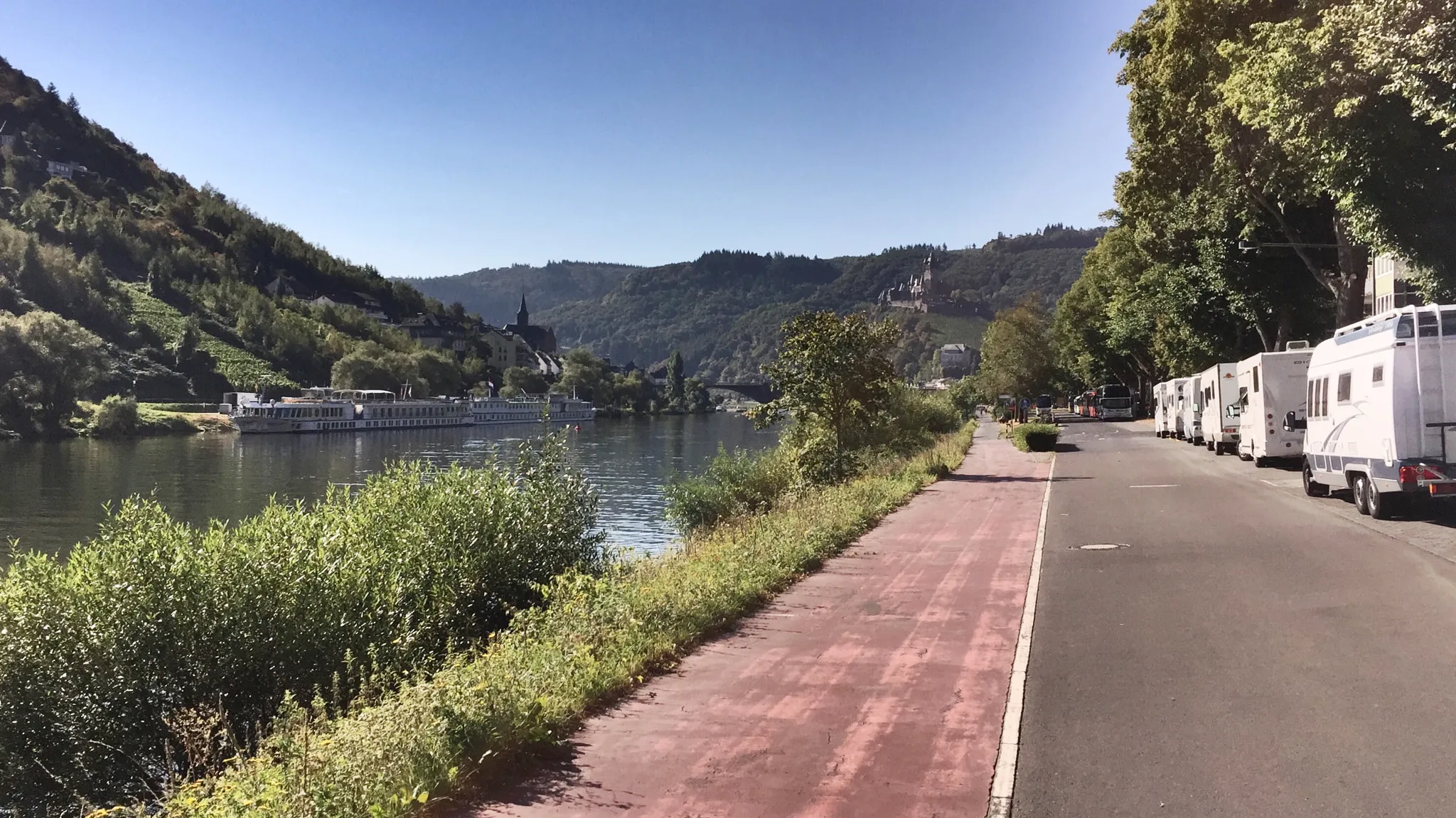 Wohnmobile am Moselufer in Cochem, gegenüber Hotelschiffe am Anleger und die Reichsburg über dem Ort