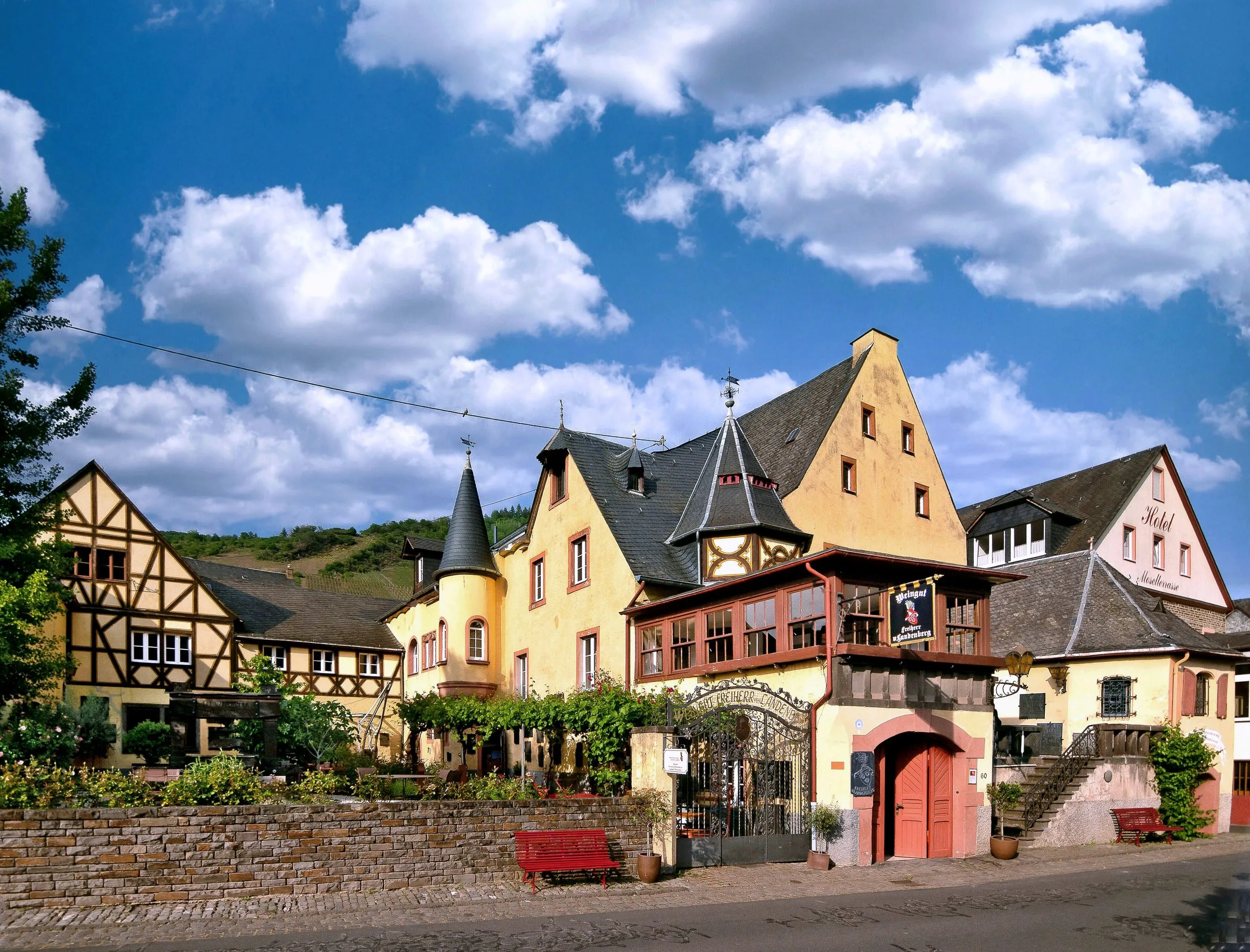 Ehemalige kurfürstliche Kellnerei in Eller: gelbe Giebelhäuser mit Erkerturm und schmiedeeisernem Hoftor an der Dorfstraße