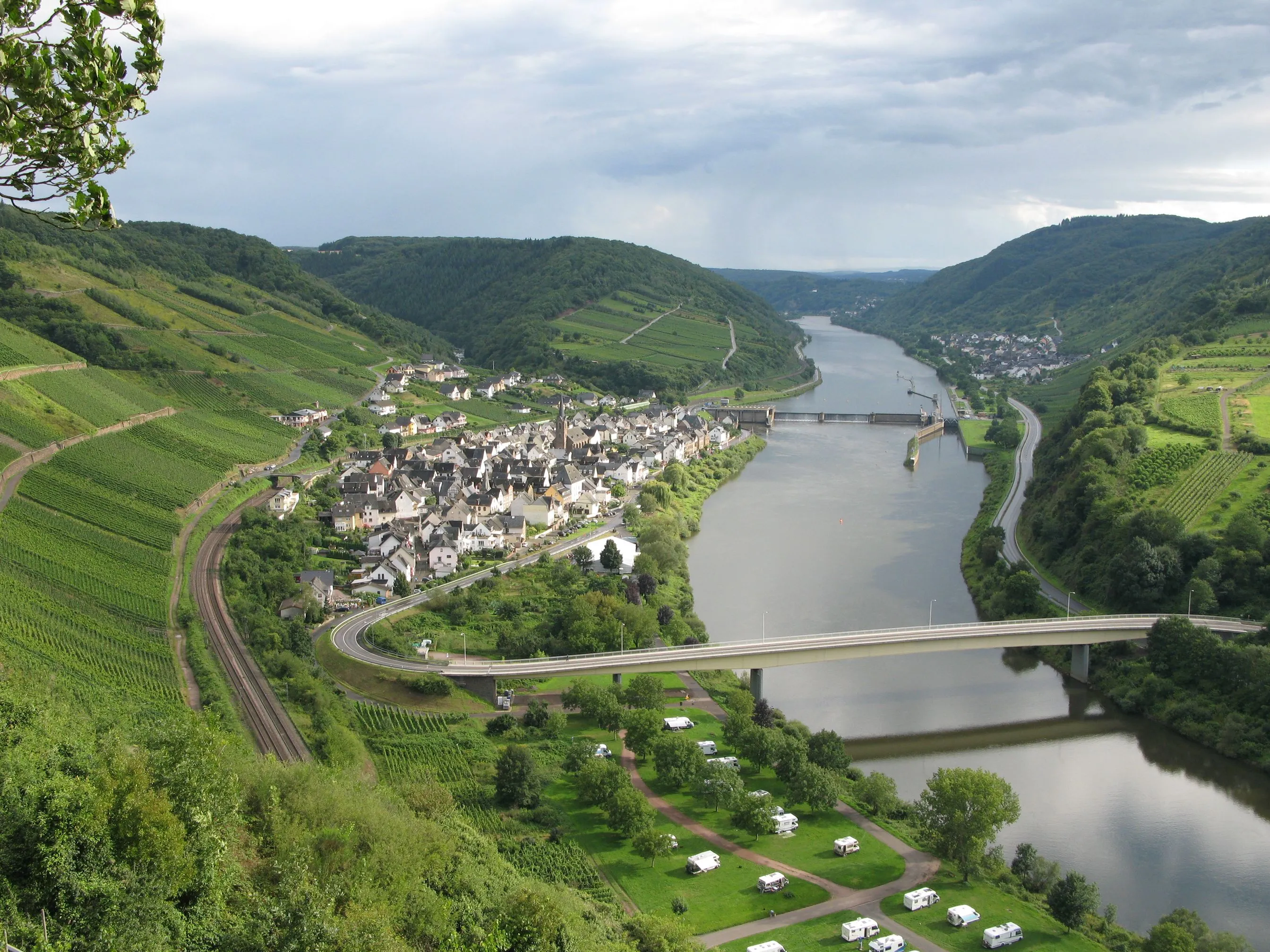 Blick vom Petersberg auf Neef an der Mosel mit Moselbrücke, Wohnmobilstellplatz am Ufer und Weinbergen an beiden Hängen