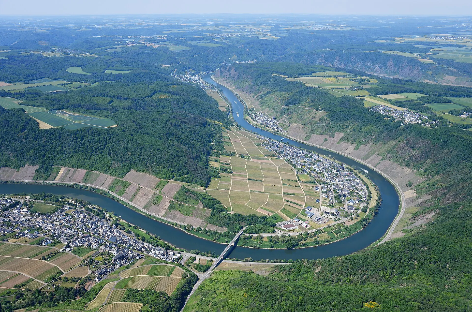 Luftbild der Moselschleife bei Ernst: der Ort am inneren Ufer, davor die Weinberge in der Flussschleife