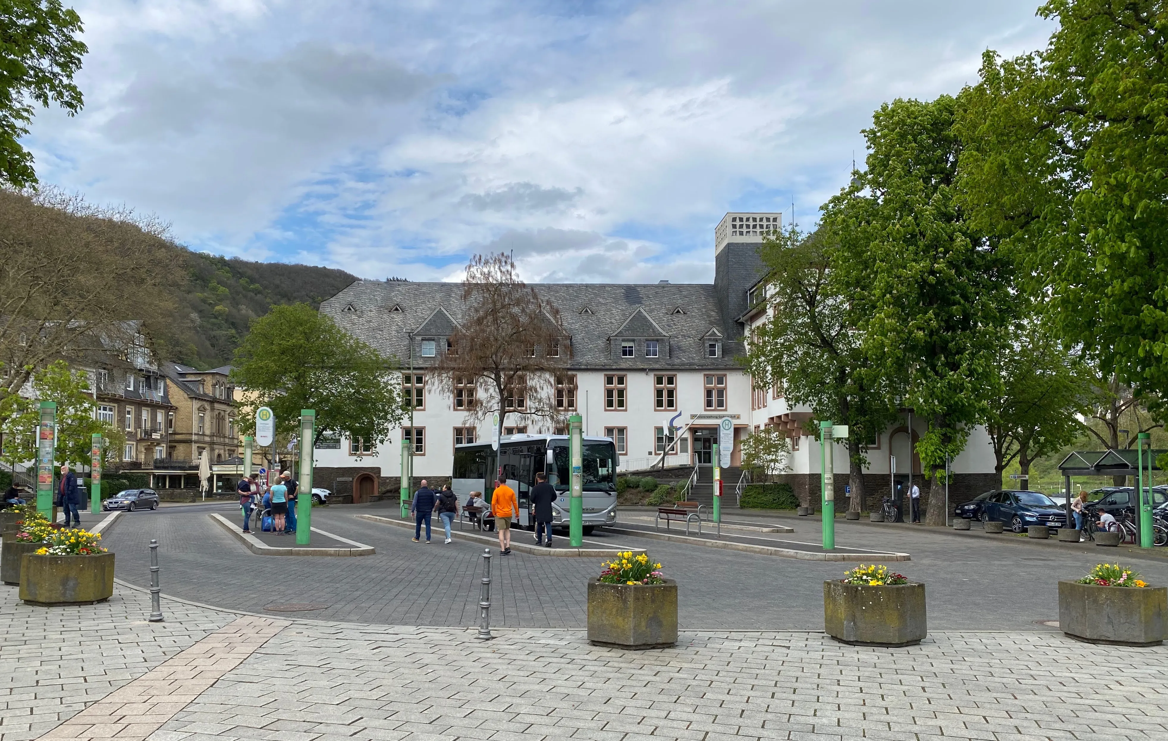 Der Endertplatz in Cochem mit Haltestellenmasten, einem wartenden Linienbus und dem Gebäude der Kreisverwaltung