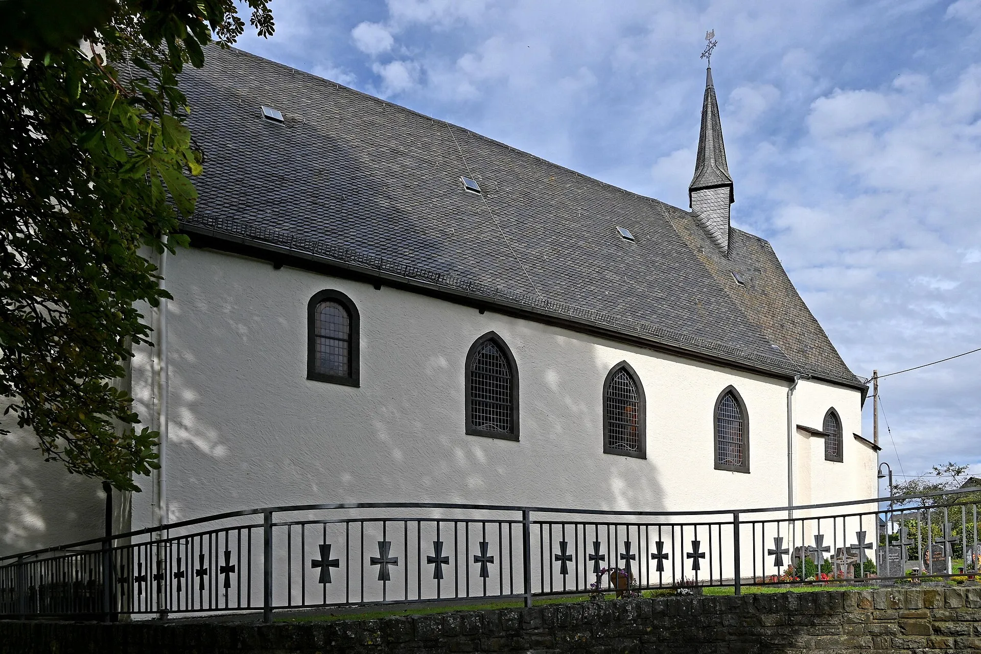 Südseite des Kirchenschiffs von St. Johannes der Täufer in Alflen mit Schieferdach und dem Dachreiter über dem Chor