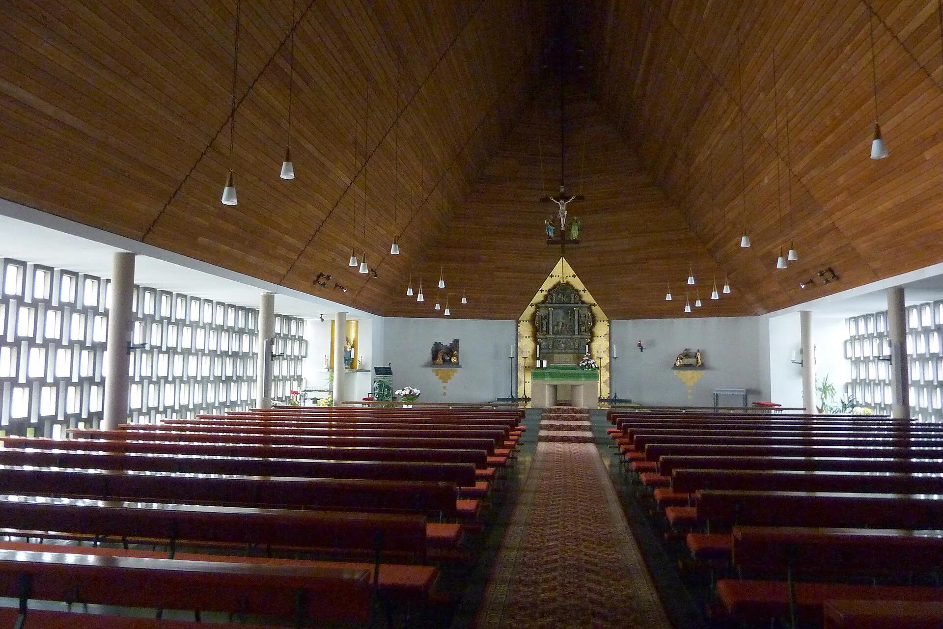 Innenraum der Pfarrkirche St. Hubertus in Gevenich mit hölzerner Zeltdecke, Betonglasfenstern und dem Altaraufsatz im Chor