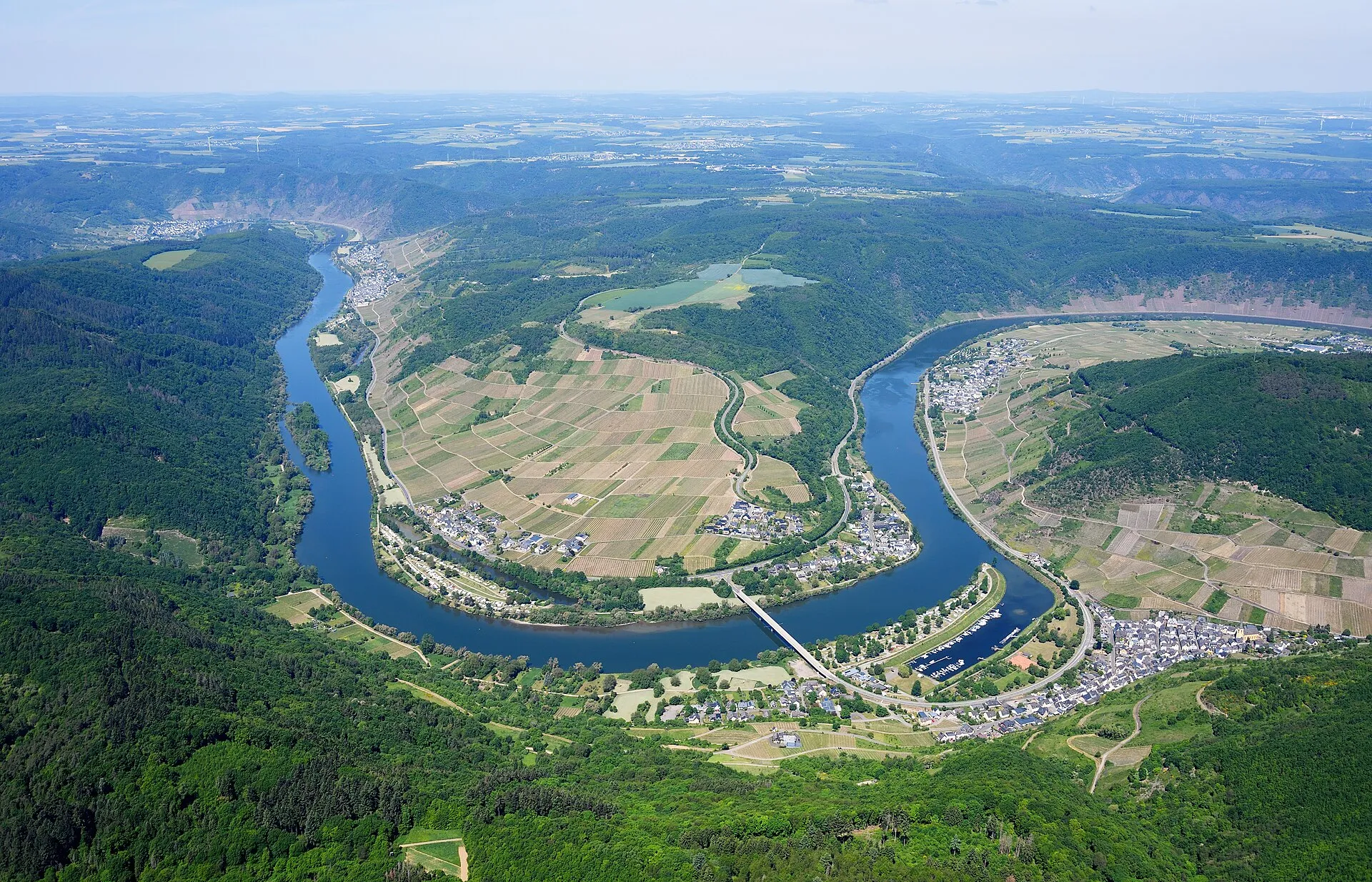 Luftbild der Moselschleife bei Senheim: Yachthafen mit Stegen auf der Halbinsel, ringsum Weinberge, Ortslagen und Wald